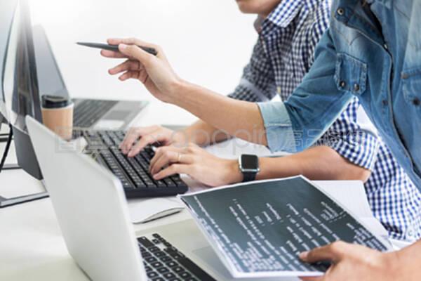 亚洲团队外包开发人员使用笔记本电脑软件寻找屏幕编程代码